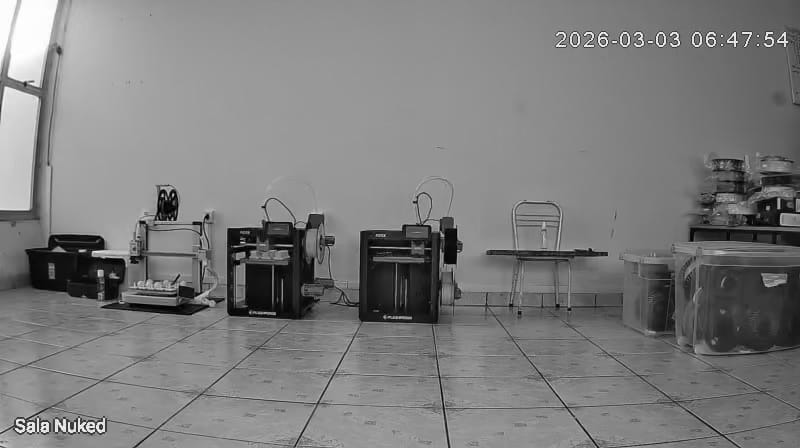 Sala Nuked inicial gravada pela câmera de segurança com impressoras 3D no chão